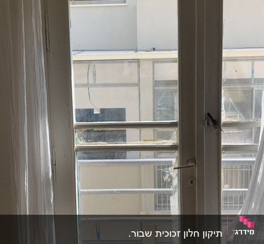 דלת זכוכית עם וילון לבן ברקע